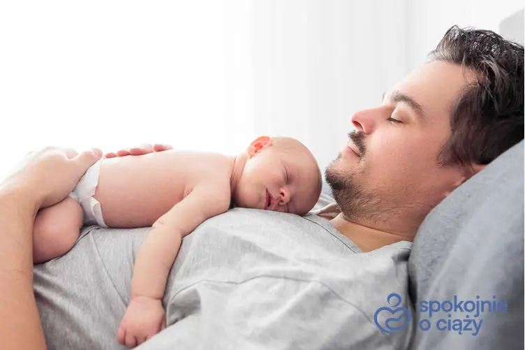 Dziecko i śpiący ojciec, a także urlop ojcowski 2023 i wniosek, ile trwa urlop tacierzyński