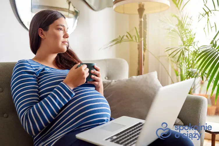 Kobieta w ciąży siedząca na kanapie, a także badanie antygenu HBS w ciąży i najważniejsze informacje