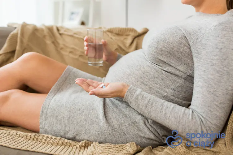 Kobieta w zaawansowanej ciąży trzymająca lekarstwa, a także no-spa w ciąży krok po kroku
