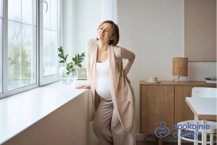Kobieta w ciąży trzymająca się za plecy, a także ból pochwy w ciąży, jego przyczyny i leczenie