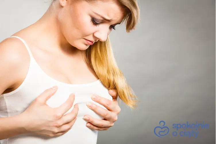 Kobieta trzymająca się za bolące przed okresem piersi, a także ból w piersiach przed okresem a ciąża bez tajemnic