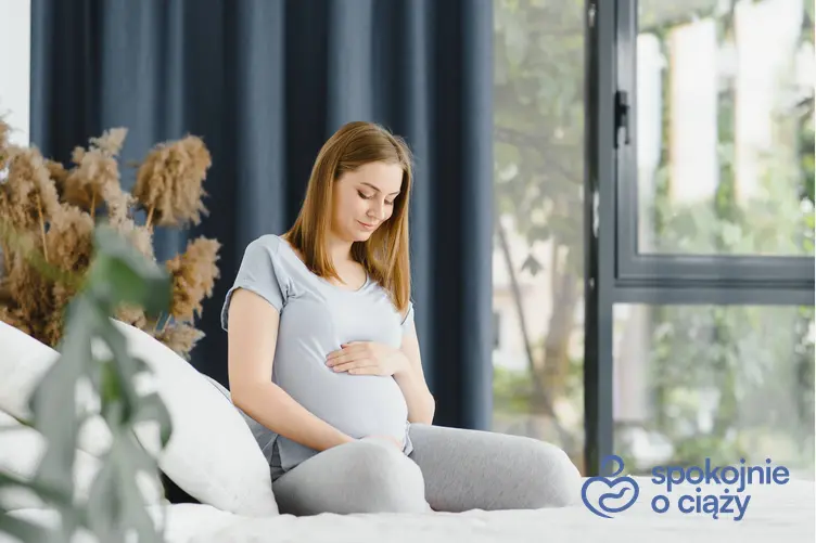 Kobieta w ciąży trzymająca się za brzuch, a także informacje, jak wygląda 10 tydzień ciąży bez tajemnic