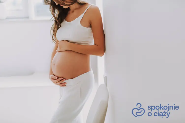 Kobieta w zaawansowanej ciąży trzymająca się za brzuszek, a także twardy brzuch w ciąży krok po kroku