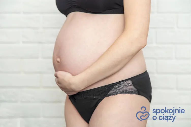 Kobieta w zaawansowanej ciąży trzymająca się za brzuch, a także uczucie rozpierania w pochwie w ciąży