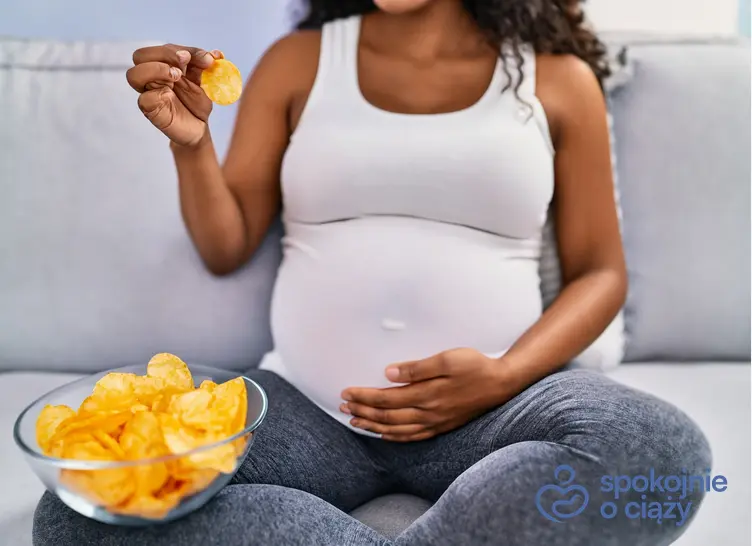 Kobieta w zaawansowanej ciąży jedząca chipsy, a także czy w ciąży można jeść chipsy