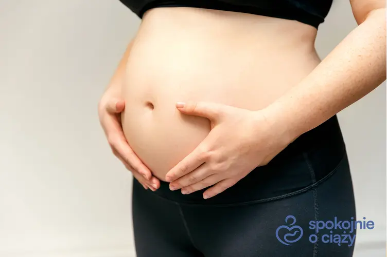 Kobieta w ciąży trzymająca się za brzuch, a także 22 tydzień ciąży krok po kroku
