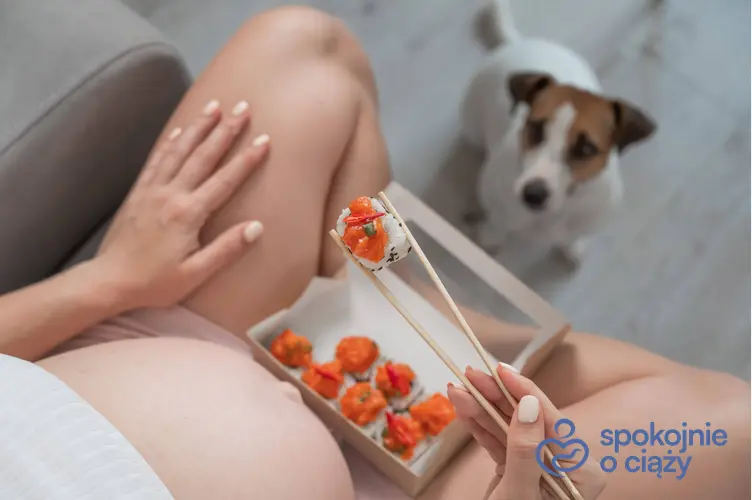 Kobieta w ciąży jedząca sushi i utkwiony w nią wzrok psa, a także sushi z surową rybą w ciąży