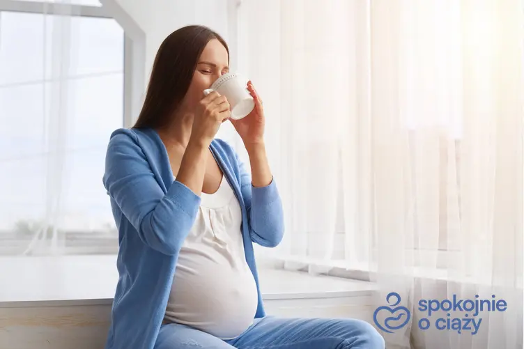 Kobieta w zaawansowanej ciąży pijąca pokrzywę z kubka, a także picie pokrzywy w ciąży