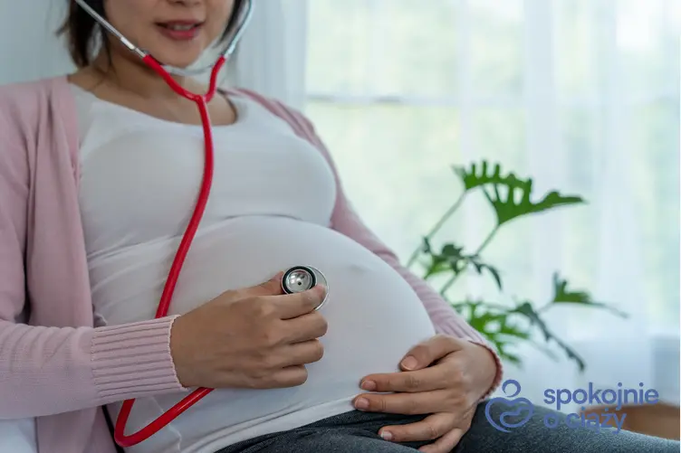 Kobieta w zaawansowanej ciąży trzymająca się za brzuch, a także 27 tydzień ciąży krok po kroku