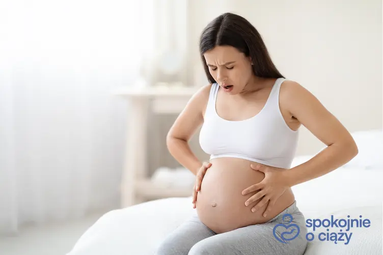 Kobieta w zaawansowanej ciąży trzymająca się za brzuch, a także ból jajników we wczesnej ciąży