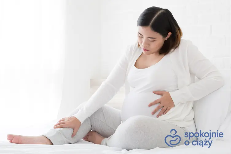 Kobieta w zaawansowanej ciąży trzymająca się za brzuch, a także ból jajników we wczesnej ciąży
