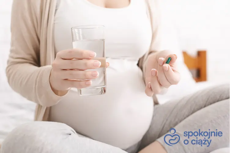 Kobieta w zaawansowanej ciąży trzymająca lek oraz stosowanie Espumisanu w ciąży
