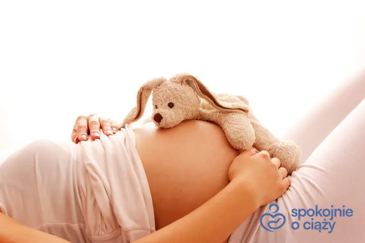 Kobieta w zaawansowanej ciąży z misiem na brzuchu, a także hashimoto a ciąża