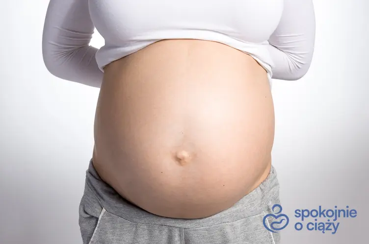 Zbliżenie na brzuch kobiety w zaawansowanej ciąży, a także cytomegalia w ciąży krok po kroku