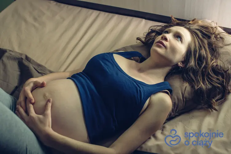 Kobieta w zaawansowanej ciąży leżąca na plecach, a także porady, jak spać w ciąży