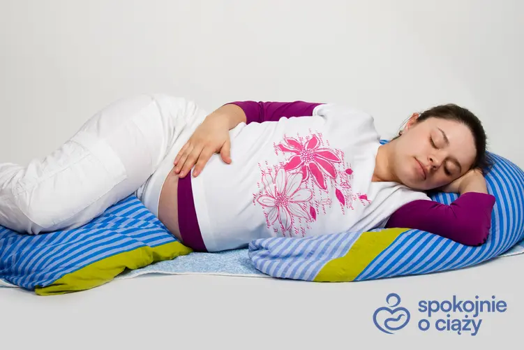Kobieta w zaawansowanej ciąży śpiąca na boku, a także porady, jak spać w ciąży
