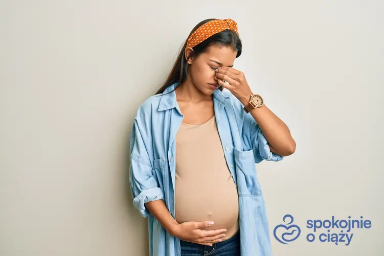 Kobieta w zaawansowanej ciąży trzymająca się za nos, a także krew z nosa w ciąży