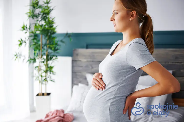 Kobieta w zaawansowanej ciąży trzymająca się za plecy, a także ból pleców w ciąży