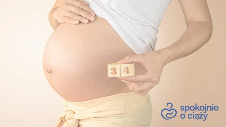 Kobieta w zaawansowanej ciąży trzymająca numer 34, a także 34 tydzień ciąży krok po kroku