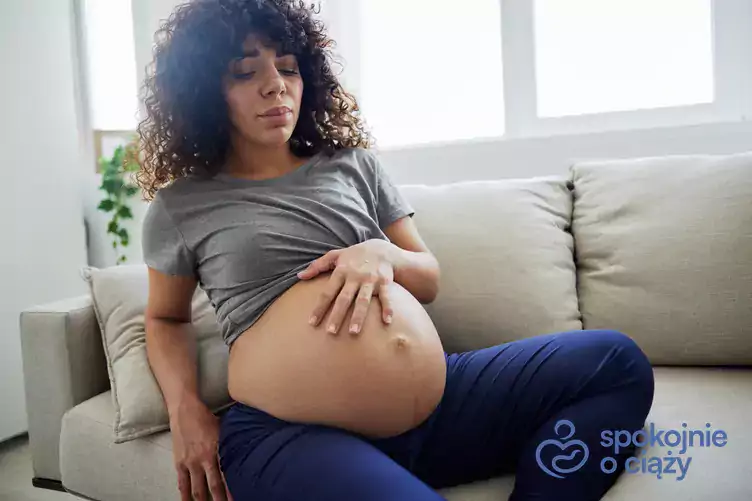 Kobieta w ciąży trzyma brzuch