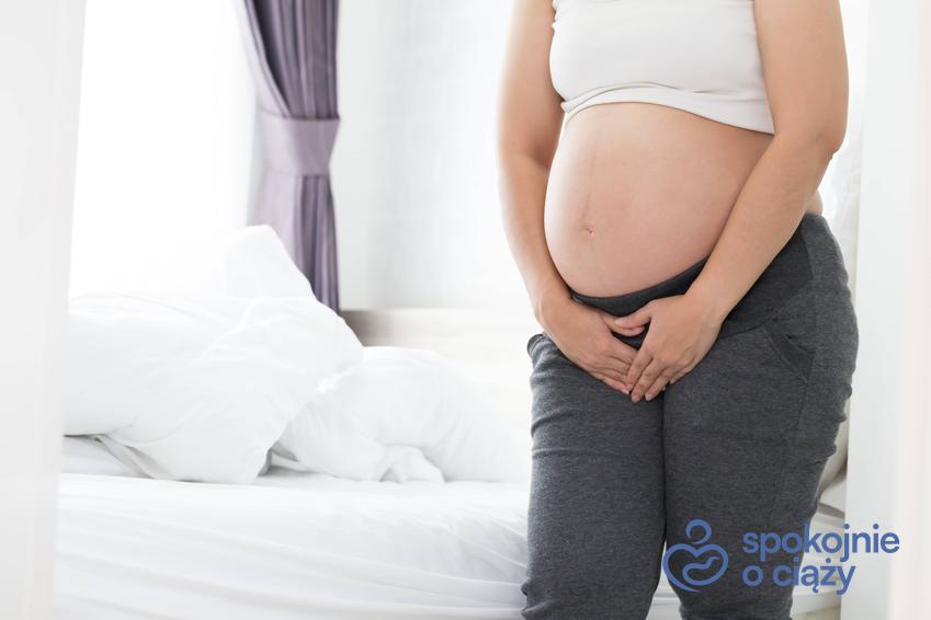 Kobieta w zaawansowanej ciąży trzymająca się na podbrzusze, a także infekcja intymna w ciąży krok po kroku