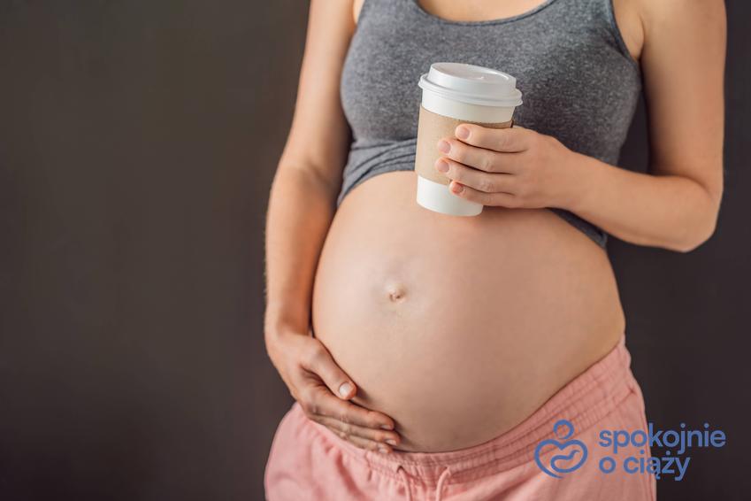Kobieta w zaawansowanej ciąży z dużym brzuchem i kubkiem kawy na wynos, a także informacje na temat picia kawy w ciąży