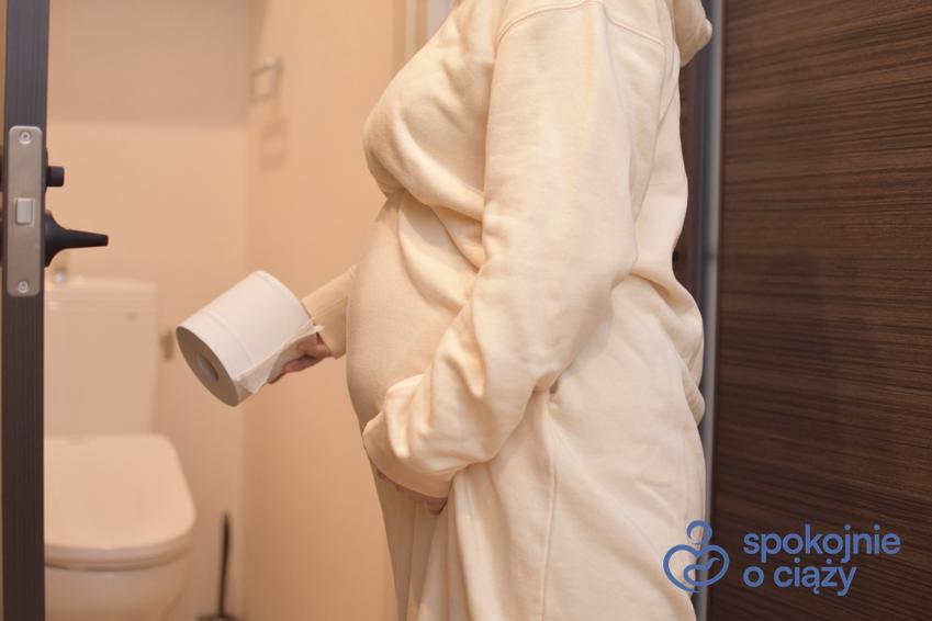 Kobieta w ciąży w łazience trzymająca papier toaletowy, a także biegunka w ciąży krok po kroku