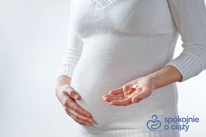 Kobieta w zaawansowanej ciąży trzymająca się za brzuch, a także luteina w ciąży krok po kroku
