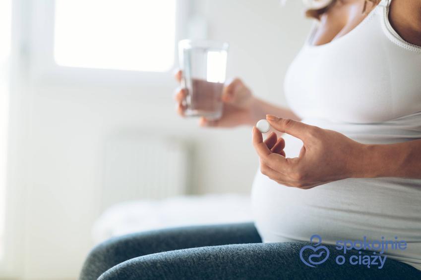 Kobieta w zaawansowanej ciąży siedząca z lekiem, a także luteina w ciąży i jej dawkowanie