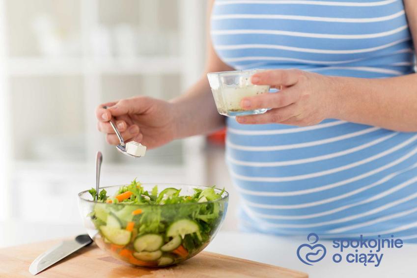 Kobieta w ciąży robiąca sałatkę z serem feta, a także ser feta w ciąży i jego wpływ na dziecko