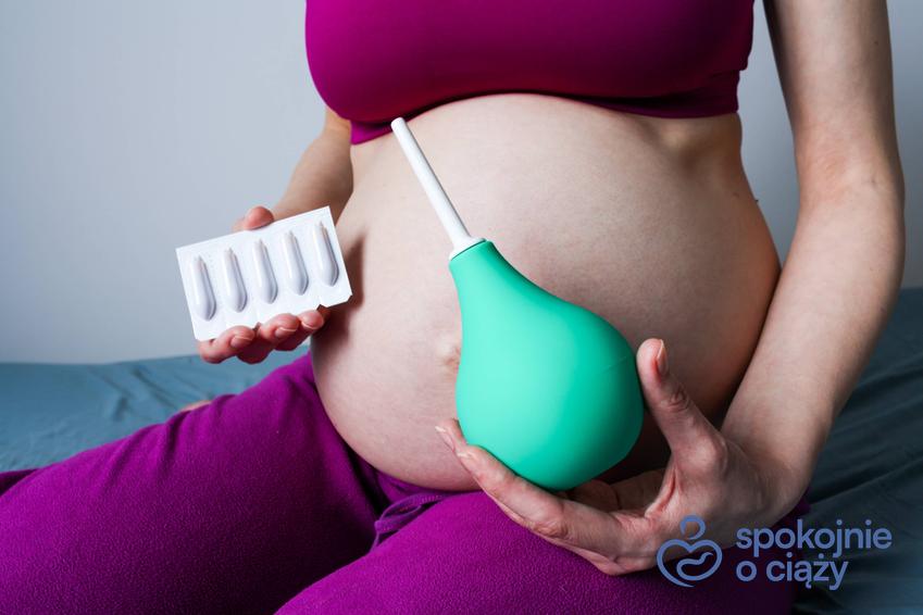Kobieta w zaawansowanej ciąży trzymająca gruszkę do lewatywy, a także lewatywa przed porodem krok po kroku