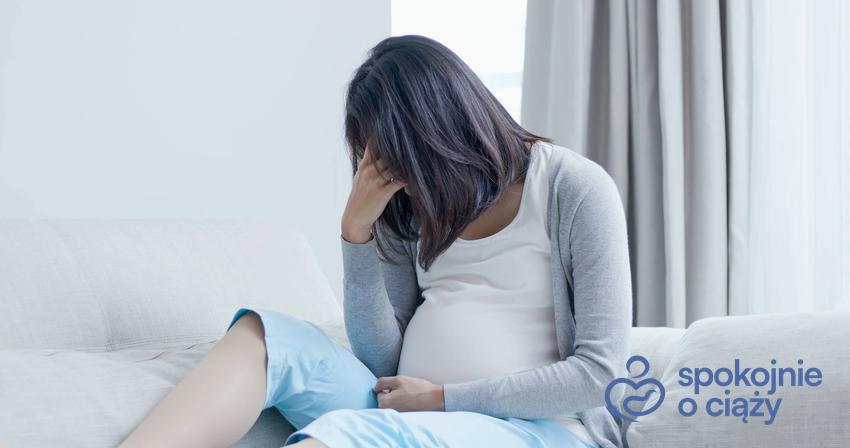 Kobieta w zaawansowanej ciąży siedząca smutna na łóżku, a także depresja w ciąży krok po kroku