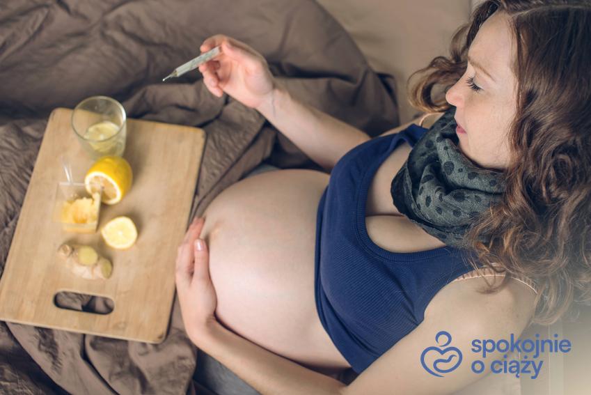 Kobieta w zaawansowanej ciąży leżąca w łóżku, a także imbir i cytryna na tacy oraz czy imbir w ciąży jest bezpieczny