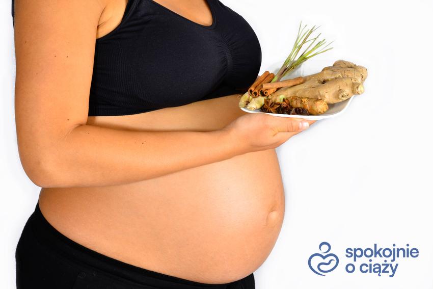 Kobieta w zaawansowanej ciąży trzymająca imbir na wysokości brzucha, a także czy imbir w ciąży jest bezpieczny