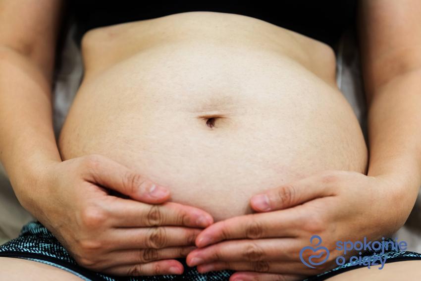 Kobieta eksponująca brzuszek w 13 tygodniu ciąży, a także 13 tydzień ciąży i jego przebieg krok po kroku