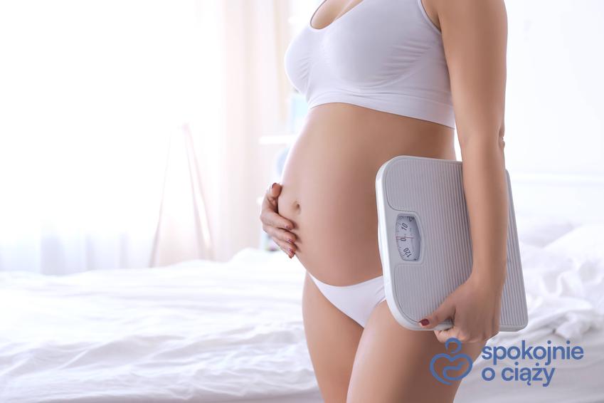Kobieta w zaawansowanej ciąży trzymająca wagę pod pachą, a także prawidłowa waga w ciąży krok po kroku