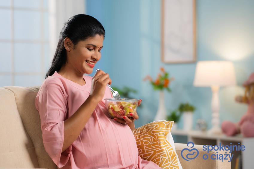 Kobieta w ciąży jedząca posiłek, a także porady położnej, czego nie można jeść w ciąży