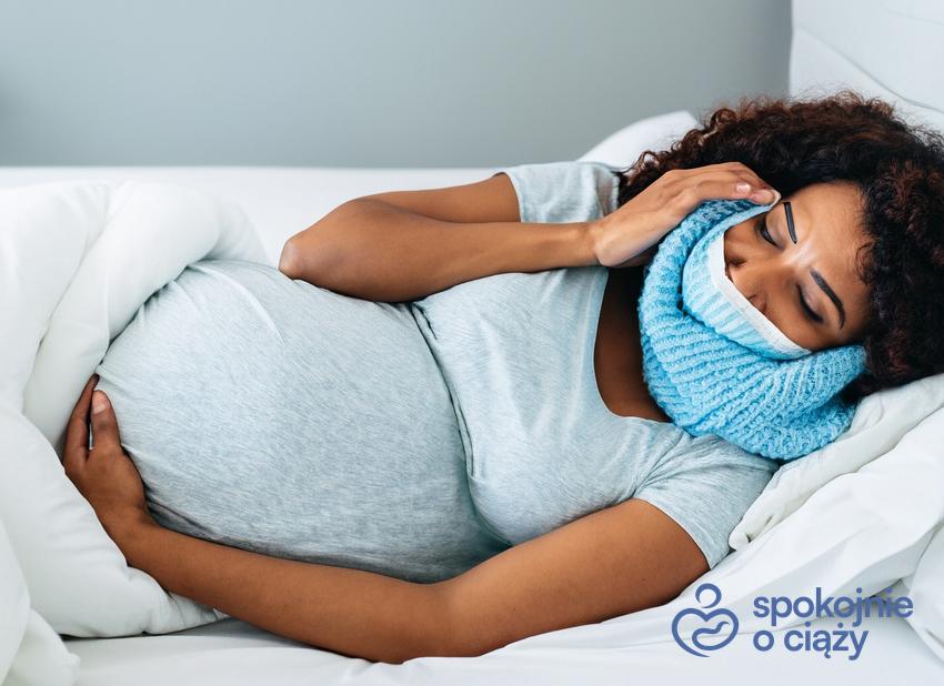 Chora kobieta w zaawansowanej ciąży leżąca w łóżku, a także porady położnej, co na przeziębienie w ciąży