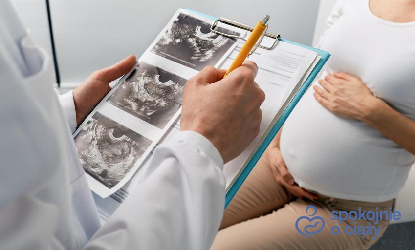 Kobieta w zaawansowanej ciąży podczas wizyty u lekarza i interpretacji wyników, a także jakie badania w ciąży wykonać