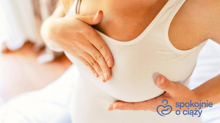 Kobieta w ciąży trzymająca się za pierś, a także brodawki sutkowe w ciąży bez tajemnic
