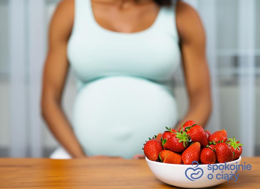 Kobieta w zaawansowanej ciąży przed miską truskawek, a także truskawki w ciąży krok po kroku