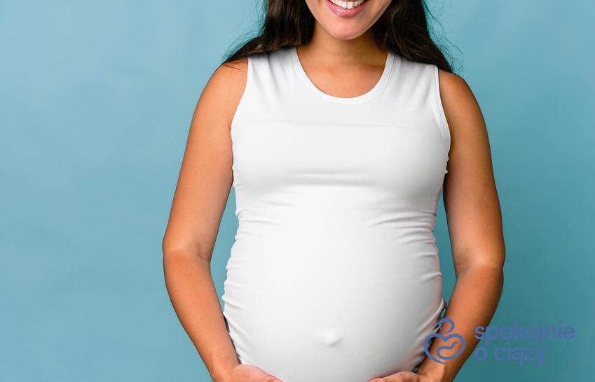 Kobieta w ciąży trzymająca się za brzuch, a także 16 tydzień ciąży krok po kroku