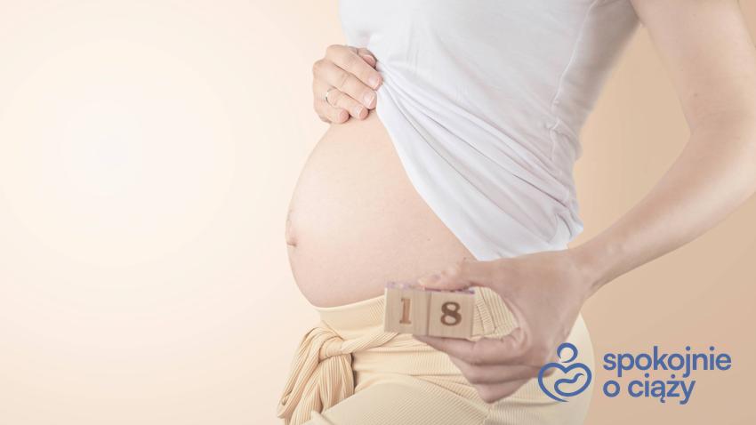 Kobieta w ciąży trzymająca się za brzuch, a także 18 tydzień ciąży krok po kroku