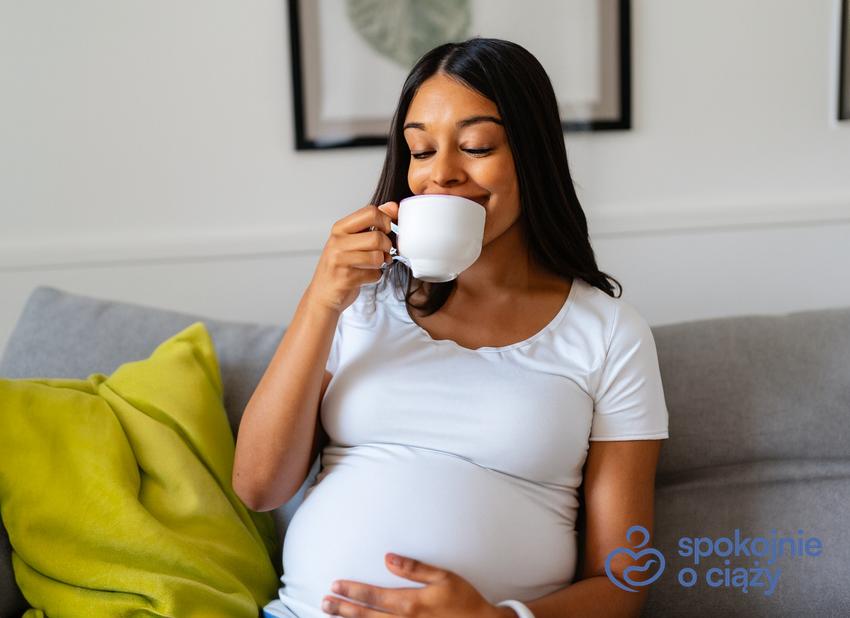 Kobieta w zaawansowanej ciąży pijąca herbatę, a także informacje, czy czarna herbata w ciąży jest bezpieczna