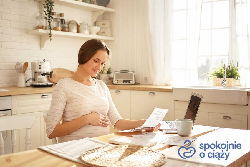 Kobieta w ciąży wypełniająca dokumenty, a także wniosek o urlop macierzyński i jego wzór