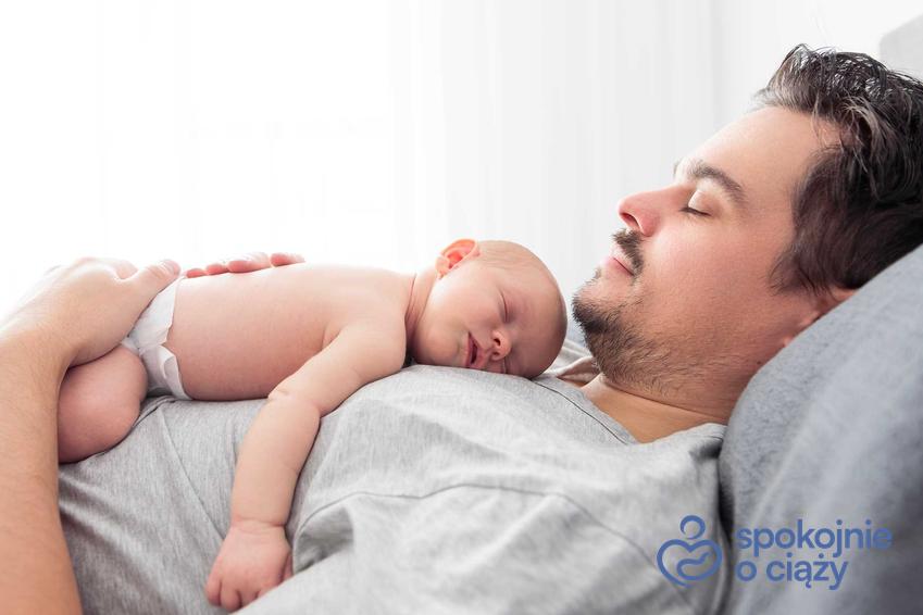 Dziecko i śpiący ojciec, a także urlop ojcowski 2023 i wniosek, ile trwa urlop tacierzyński